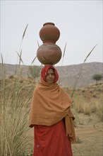 Woman Balancing Clay Pots on Head