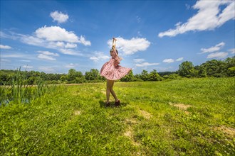 Young Adult Woman in Pink Dress Dancing in Field