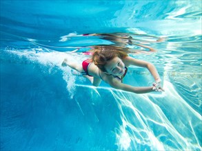 Girl Swimming Underwater in Pool