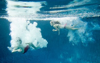 Boy and Girl Underwater in Pool