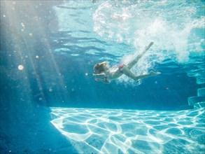 Girl Swimming Underwater in Pool, Profile
