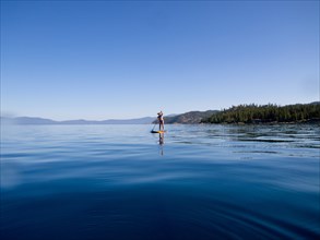 Woman Paddling on Lake in Distance