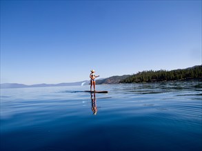 Woman on Paddleboard on Lake