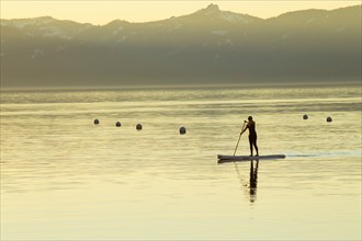 Woman on Paddle Board at Sunset, Lake Tahoe, Nevada, USA