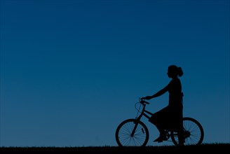 Young Woman Riding Bicycle, Silhouette