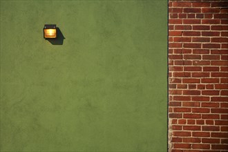 Light Fixture on Green Wall With Red Brick Wall Border