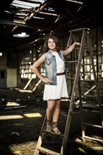 Girl Standing on Ladder in Abandoned Warehouse
