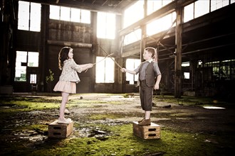 Two Children Play Fighting in Abandoned Warehouse