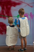 Two Young Boys Painting on Wall