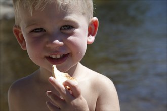 Smiling Boy Eating Bread