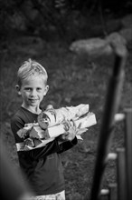 Young Boy Holding Stack of Wood