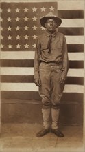 Full-length Portrait of an African American Soldier in Uniform with American Flag in Background, William A. Gladstone Collection of African American Photographs, 1914-18