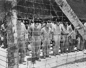 Japanese POW, with heads bowed after hearing Emperor Hirohito make Announcement of Japan's Unconditional Surrender, Guam, U.S. Navy Photo, August 15, 1945