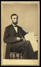 Full-Length Seated Portrait of Abraham Lincoln Holding Eyeglasses and Paper, Washington DC, USA, Photograph by Alexander Gardner, August 9, 1863
