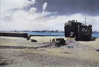 Trucks Exit From The Hold Of A US Naval LST on Beach After Storm Wrecked Artificial Mulberry Harbors, Normandy, France, June 1944