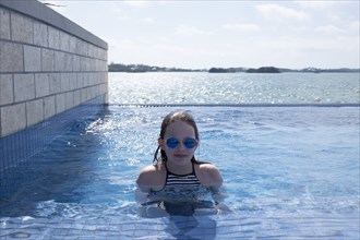 Portrait of Girl in Sunglasses in Infinity Pool
