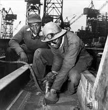 A Chipper Removing Excess Metal from a Welded Seam during Construction of the Liberty Ship Frederick Douglass, Bethlehem-Fairfield Shipyards, Baltimore, Maryland, USA, Roger Smith, U.S. Office of War ...