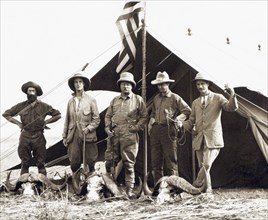 Former U.S. President Theodore Roosevelt (center) with L-R: Hunter R. J. Cunninghame, son Kermit Roosevelt,  Edmund Heller, and Hugh H. Heatley, Full-Length Portrait standing with African Buffalo Skul...