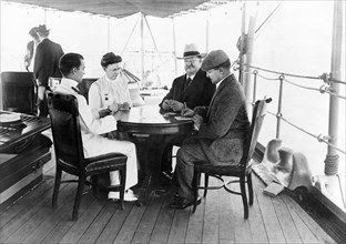 William Howard Taft Playing Cards with his Wife Helen Herron Taft and Two Men on boat enroute to Philippines where Taft was to head up the 2nd Philippine Commission (aka Taft Commission), April 1900