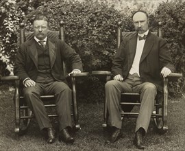 U.S. President Theodore Roosevelt and Vice President Charles Fairbanks, seated in rocking chairs, facing front, on lawn at Sagamore Hill, Cove Neck, New York, USA, Pach Brothers, 1904
