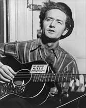 Woody Guthrie (1912-1967), Half-Length Portrait Playing Guitar, Photograph by Al Aumuller, World Telegram, 1943