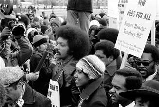 Jesse Jackson speaking into a microphone, surrounded by marchers carrying signs advocating support for the Hawkins-Humphrey Bill for full employment, Washington, D.C., USA, photograph by Thomas J. O'H...