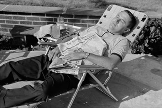 Man Sleeping in Lounge Chair with Newspaper across his Chest, Washington, D.C., USA, photograph by Thomas J. O'Halloran, August 1962