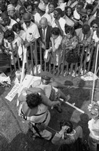 Crowd of African Americans behind a storm fence with police carrying a woman on the other side during March on Washington for Jobs and Freedom, Washington, D.C. USA, photograph by Marion S. Trikosko, ...