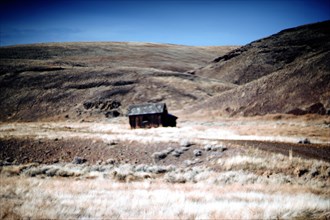 Old Wood Cabin amongst Rural Plains Landscape