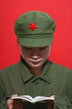Head and Shoulders Portrait of Asian Woman in Uniform Reading a Book