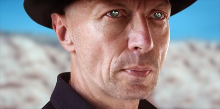 Close-up Portrait of Man in Cowboy Hat against Desert Background