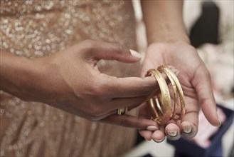 Woman Holding Gold Bracelets
