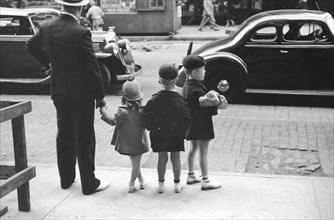Father and three children waiting to cross the street