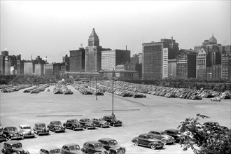 Parking Lot full of Cars with Cityscape in Background