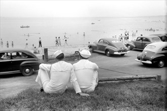 Rear View of Two Sailors Watching Beach Crowd