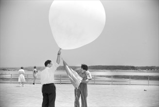 Two Men preparing to send up Weather Balloon at Weather Bureau at Airport