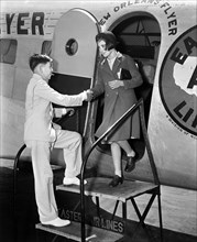 Teen Boy helping Teen Girl off New Orleans Flyer Airplane