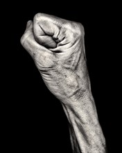 Mid-Adult Woman's Clenched Fist against Black Background