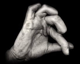 Hand with Contorted Fingers against Black Background