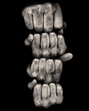 Four Stacked Fists against Black Background