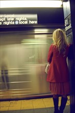 Rear View of Woman Standing on Subway Platform