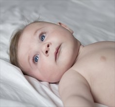 Head and Shoulders Portrait of Cute Baby Laying on Blanket