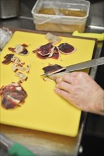 Chef thinly slicing Cured Meat