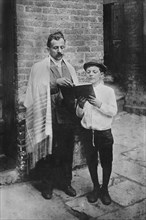 Rabbi and Boy reading Book while standing outside