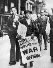 Newspaper Man holding Stack of Newspapers and Sign stating "Special Late News: War - Official"