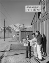 Roy Takeno (Editor) and group reading Newspapers in front of Office