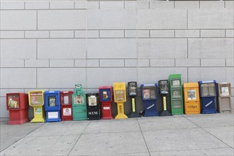 Row of Colorful Newspaper Boxes on Sloping Sidewalk