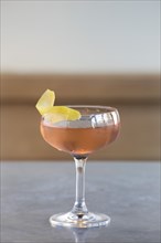 Pink Cocktail with Lemon Garnish