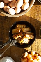 High Angle View of Apple Pastries in Cast Iron Skillet and Bowls of Eggs and Cantaloupe
