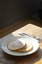 Two Pancakes with Powdered Sugar on Plate